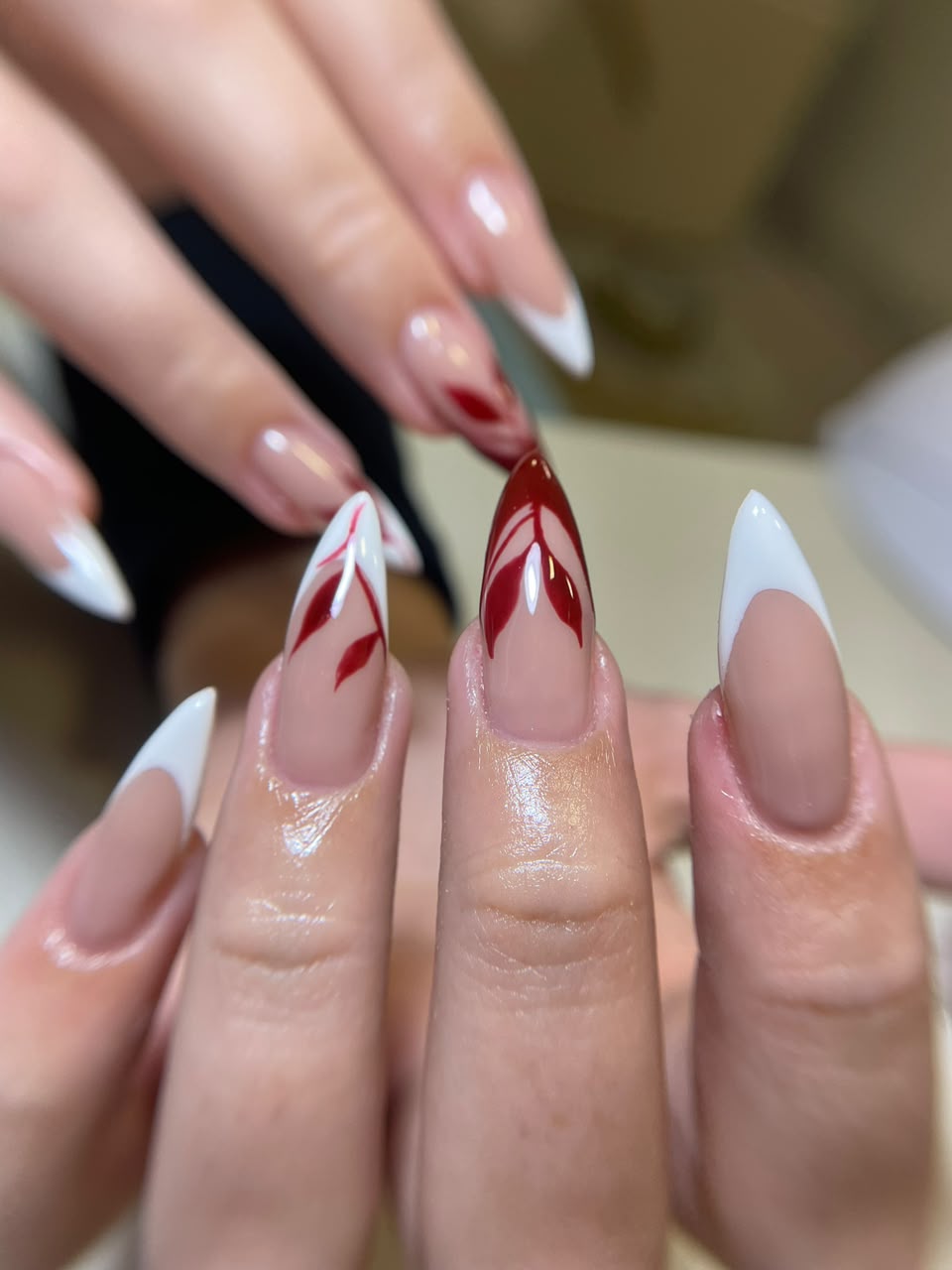 Nail art com detalhes vermelhos e acabamento sofisticado