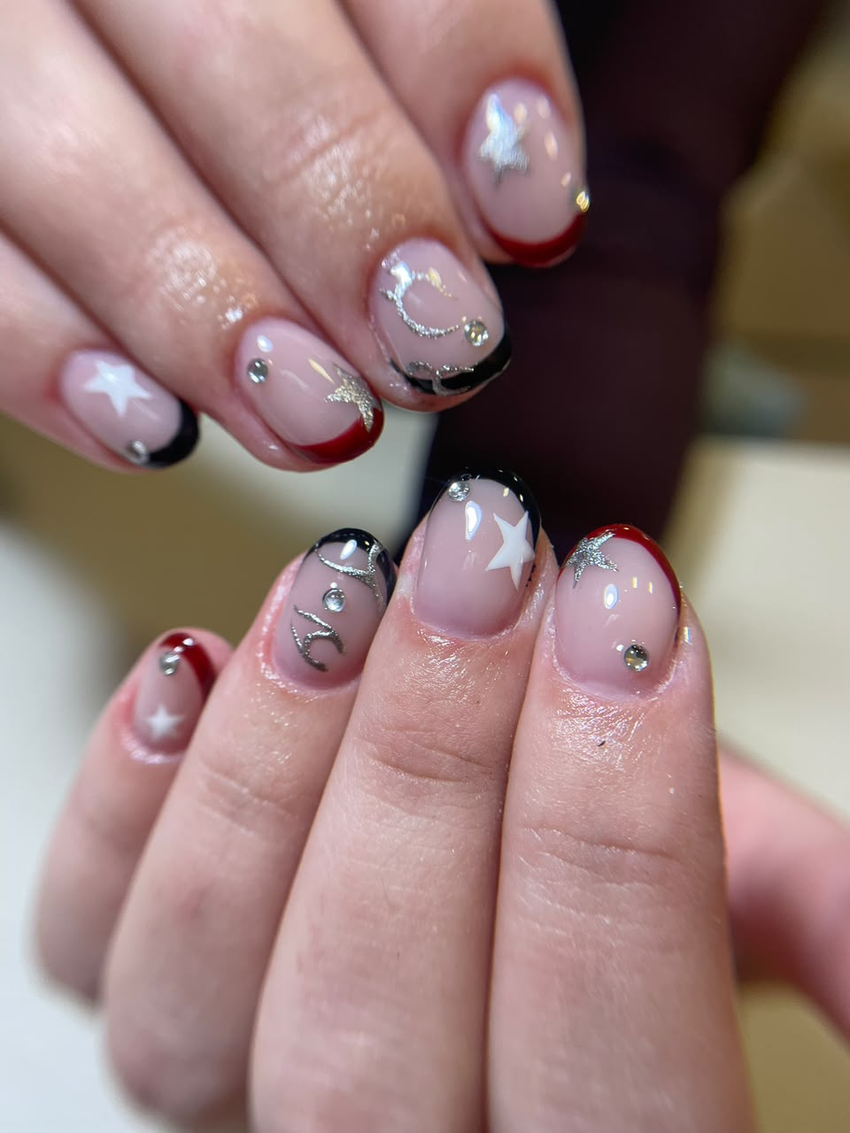 Nail art delicada com pedrarias e detalhes brilhantes
